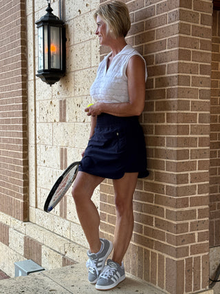 Person holding a tennis racket on a brick patio