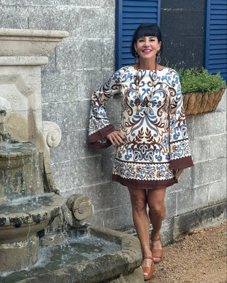 WOMAN IN PRINTED DRESS BY FOUNTAIN
