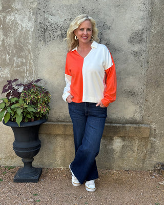 Person standing outdoors next to a planter with a neutral background