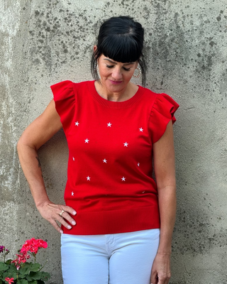 Woman in red summer sweater with flutter sleeves and white emdroidered stars