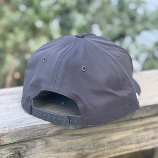 Dark gray cap on a wooden surface with a blurred natural background