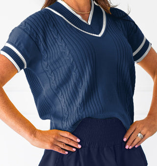 Navy blue dress with white trim worn by a person on a white background