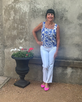 woman in cobalt blue and white print sleeveless top up against a wall