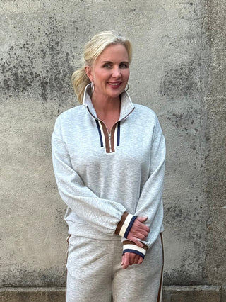 Lady on grey sweat suit with black and brown trim