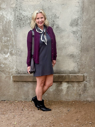 blonde woman in plum sweater and grey dress