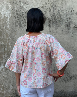 Person wearing a patterned outfit on a concrete floor