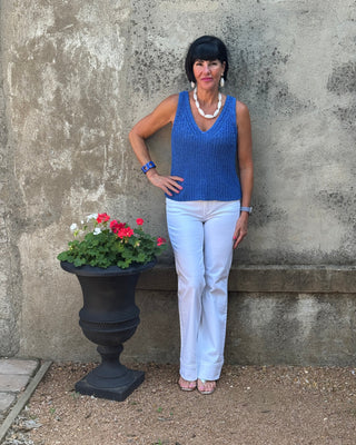 Person standing on a concrete surface with a potted plant nearby