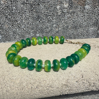 Green beaded necklace on a textured surface