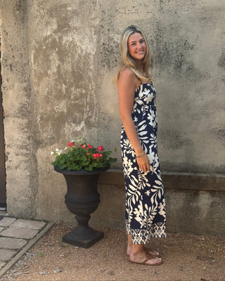 Woman standing on a concrete surface with a planter of flowers nearby