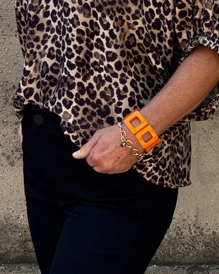 Person wearing a leopard print shirt on a concrete floor
