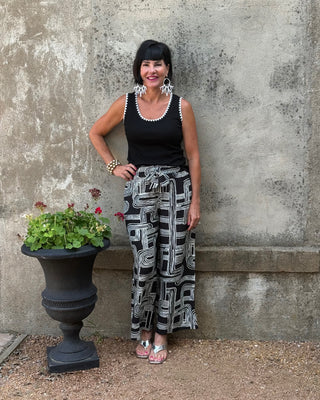 women in black top and black and white geoetric print pant