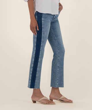 Woman wearing a light blue shirt and jeans on a beige background