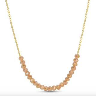 Gold necklace with beige beads on a white background