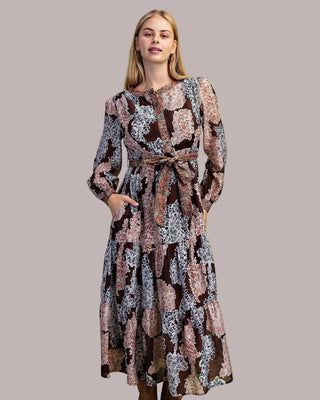 Woman wearing a patterned dress on a green background