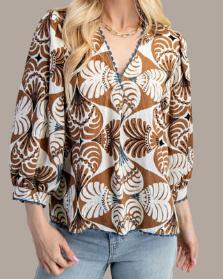 Woman wearing a patterned blouse with a plain background