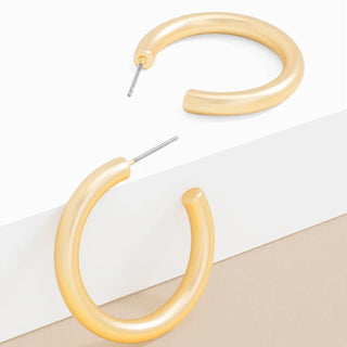 Pair of beige hoop earrings on a light background