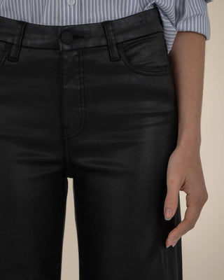 Person wearing black pants with a beige background