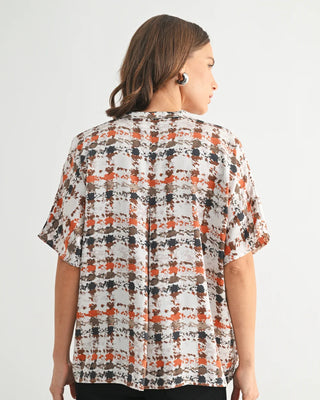 Woman wearing a patterned blouse on a white background