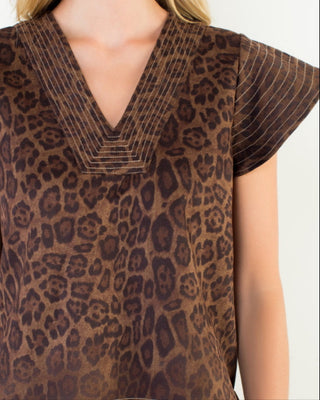 Brown leopard print top worn by a person on a white background